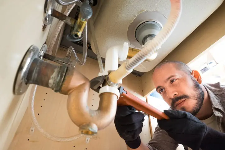 plumber working under sink